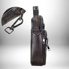 Un sac bandoulière homme cuir souple marron foncé, avec des détails métalliques argentés, est photographié de profil. Un insert montre le détail d'une boucle de crochet. Le sac a une sangle d'épaule en tissu, une poignée supérieure et plusieurs poches zippées.
 — vue 5