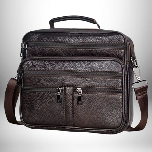 Voici une description de l'image, à la manière d'un "Alt text" :
Ce sac bandoulière homme cuir souple de couleur marron foncé est posé sur fond clair dégradé. Le sac présente une poignée sur le dessus et une bandoulière marron, détachable. Il possède plusieurs compartiments zippés sur le devant. La texture du cuir est visible en détail.
