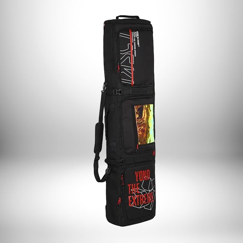 Un sac à dos snowboard noir debout, avec des accents rouges et blancs sur les poches et la fermeture éclair.