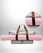 Un grand bagage a main easyjet gris-blanc avec l'étui de tapis de yoga rose attaché à la partie inférieure et une poignée en cuir brun. Il y a une vue de près d'une partie du bagage et du tapis de yoga en cercle en haut à droite de l'image.
 — vue 4