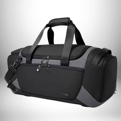 Un grand sac sport noir et gris avec des poignées et une bandoulière.
