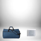 Sur fond dégradé, on aperçoit un sac de voyage convertible bleu marine, doté d'une bandoulière, d'une poignée et d'une poche zippée. À côté, un autre sac, emballé dans du plastique transparent, porte l'inscription "MIXII". — vue 7