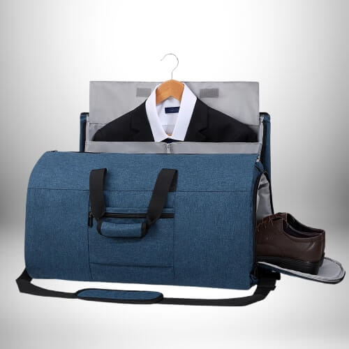 Un sac de voyage convertible bleu ouvert avec un costume sur un cintre qui est partiellement enveloppé dans le sac tout en affichant une paire de chaussures marron.