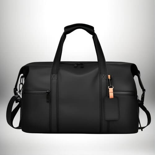 A high-angle shot displays a black duffel bag with two handles at the top, a shoulder strap, and a luggage tag.