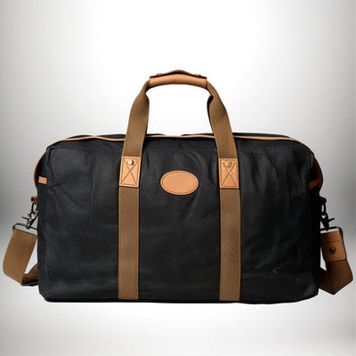 Un grand bagage a main 56x45x25 avec des poignées et une bandoulière marron sur un sac noir.
