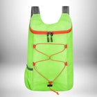 Un sac à dos vert vif avec des accents orange. Les fermetures éclair et les sangles sont également oranges et les sangles des épaules sont grises. Le sac à dos est contre un arrière-plan dégradé blanc et gris.
 — vue 5
