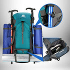 Une vue de face d'un sac à dos de trekking bleu-vert avec des bâtons de trekking, des tapis de couchage et une serviette, le sac à dos a deux poches latérales bleues avec des rouleaux bleus et un tapis de couchage roulé horizontalement en bas. Il y a une image incrustée des chaussures stockées et une autre image montrant l'attache des bâtons. — vue 6
