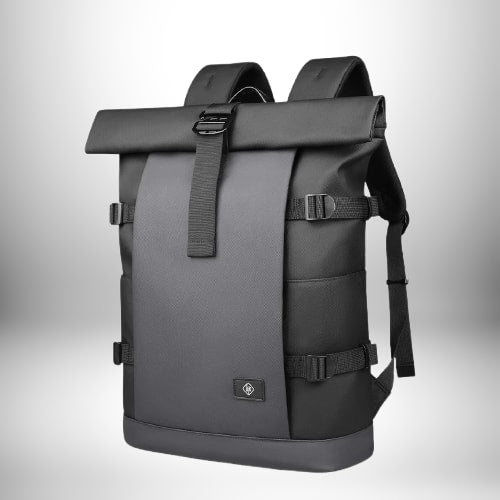 Un sac à dos noir de style urbain avec une fermeture à rabat. Le sac a des bretelles, des sangles sur le côté et une boucle sur le rabat.
