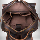 Intérieur ouvert d'un sac à dos en cuir brun, doublé d'un tissu brun. Une fermeture éclair entoure l'ouverture du sac à dos et plusieurs poches sont visibles à l'intérieur.
 — vue 7