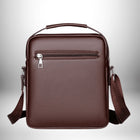 Un sac à bandoulière en cuir brun de forme rectangulaire, avec une poignée sur le dessus, une fermeture éclair à l'arrière et une bandoulière attachée. — vue 3